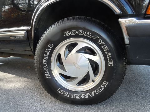 2001 Ford Crown Victoria - Close-up of a black Chevrolet Blazer's side panel and tire, showing the 'BLAZER' badge and Goodyear Wrangler tire.