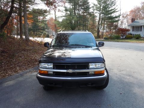 2001 Ford Crown Victoria - Black Chevrolet S-10 Blazer shown from the front on an autumn day.
