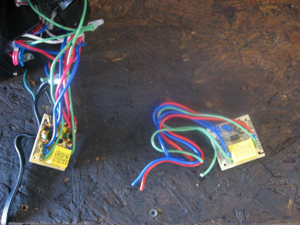 Two circuit boards with bundles of red, blue, and green wires attached. One board is larger and has more wires