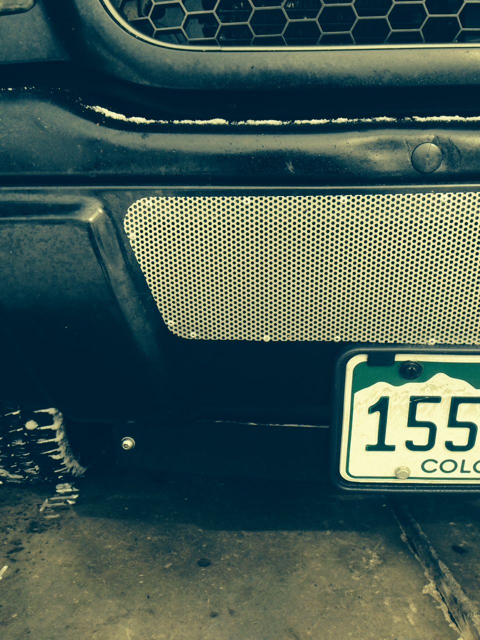 Front bumper detail showing a Colorado license plate with number 155