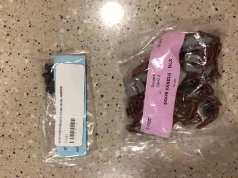 Two bags of car parts. One bag has black clips and a blue card labeled "65-67 PONY/DELUXE DOOR PANEL ARMRES".