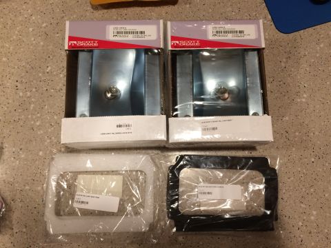 Two Scott Drake tail light assemblies in boxes and two tail light bezels in plastic packaging on a speckled co