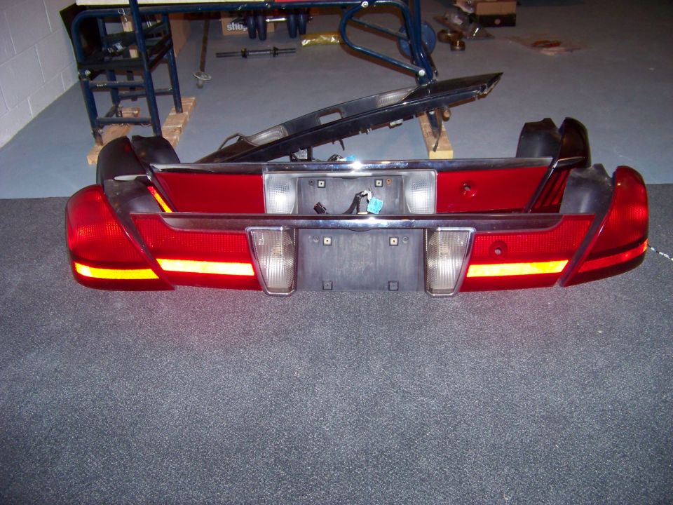 Car tail lights and bumper assembly with chrome trim and license plate holder