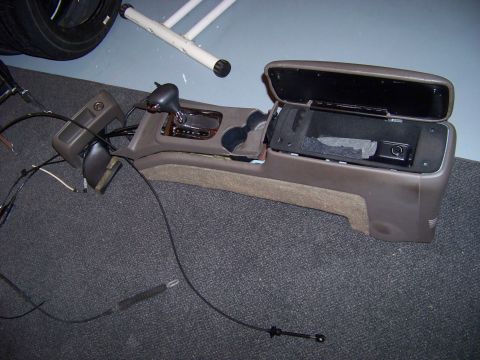 1999 Mercury Grand Marquis - The interior center console assembly, including the gear shifter and storage bin, is shown disassembled.