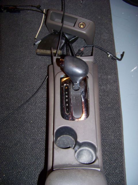 1999 Mercury Grand Marquis - The center console gear shifter assembly is shown, the P, R, N, D, 2, and 1 gear indicators.