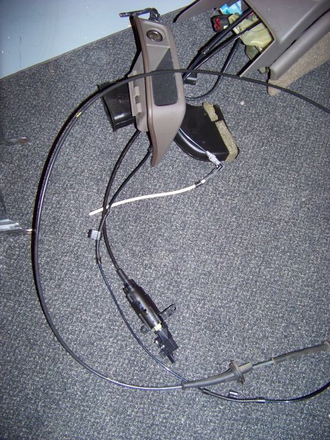 1999 Mercury Grand Marquis - Car interior console trim piece with attached cables and electrical connectors.