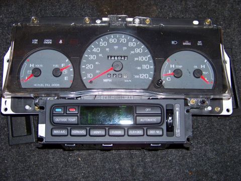 1999 Mercury Grand Marquis - A car's instrument cluster and climate control unit are shown removed from the vehicle.