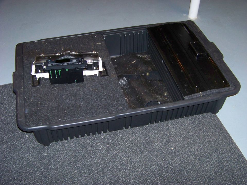 Center console storage bin with radio unit removed, showing internal wiring connectors