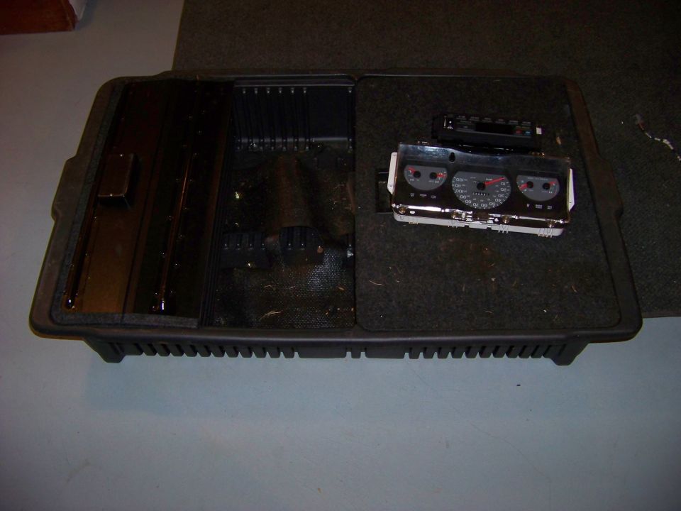 Dashboard instrument cluster with three gauges and a center console storage bin