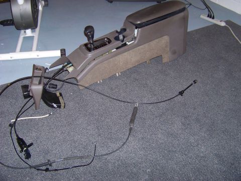 1999 Mercury Grand Marquis - Disassembled center console and gear shifter assembly with visible wiring and cables.