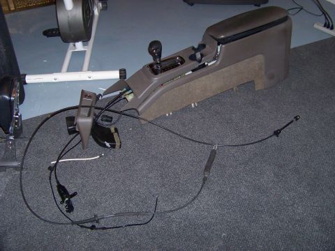 1999 Mercury Grand Marquis - Removed car center console assembly with shifter and cables spread out on the floor.