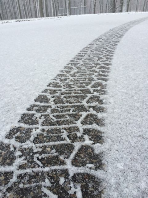 2006 Chevrolet Silverado 2500 - Tire track in snow on a road with trees in the background.