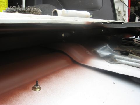 1994 Ford Bronco - Close-up view of the interior of a white vehicle, revealing a metal seam with overspray and a bolt.