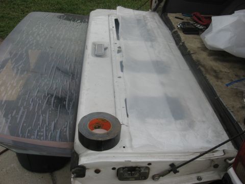 1994 Ford Bronco - Tailgate and rear window of a pickup truck covered with plastic sheeting and duct tape.