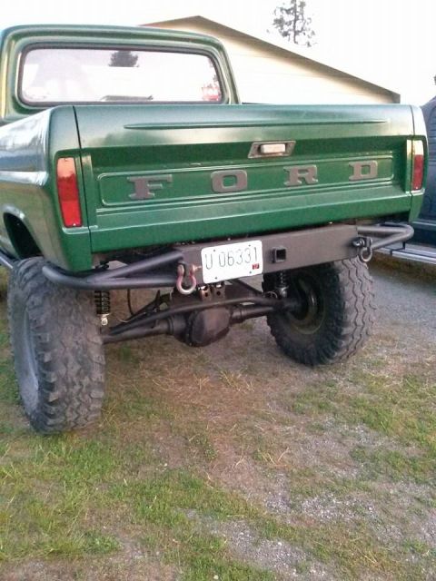 1967 Ford F-250 - Rear view of a modified green Ford pickup truck, likely from the 1970s, with off-road tires.