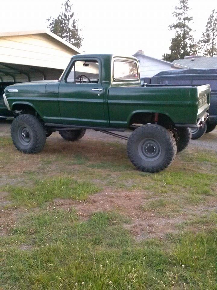 Green 1967 Ford F-250 lifted pickup truck, side view