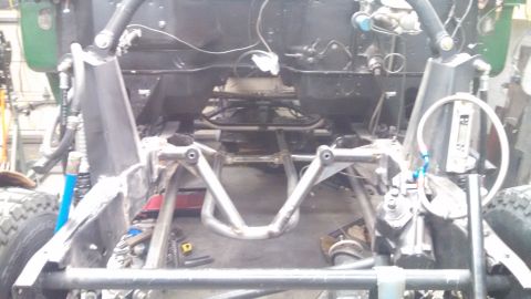 1967 Ford F-250 - The underside of a truck chassis shows custom suspension work and engine bay components.