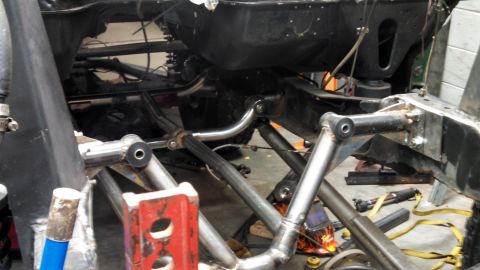 1967 Ford F-250 - Custom suspension components are visible on a vehicle frame during a build.