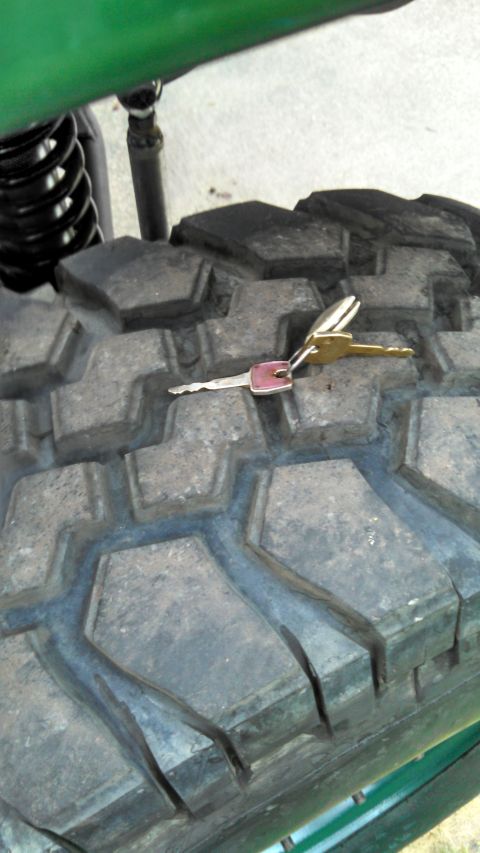 1967 Ford F-250 - Two keys sit on the aggressive tread pattern of a large tire, hinting at vehicle access.