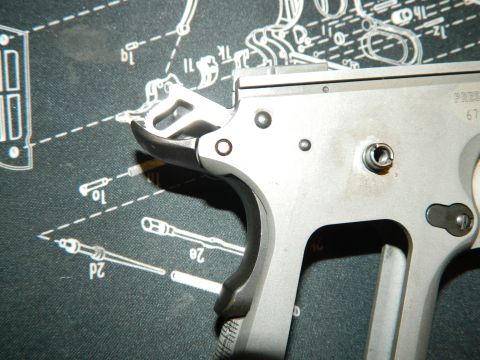 1979 Ford Bronco - A detailed view of a gun's trigger assembly is shown against a background schematic diagram.