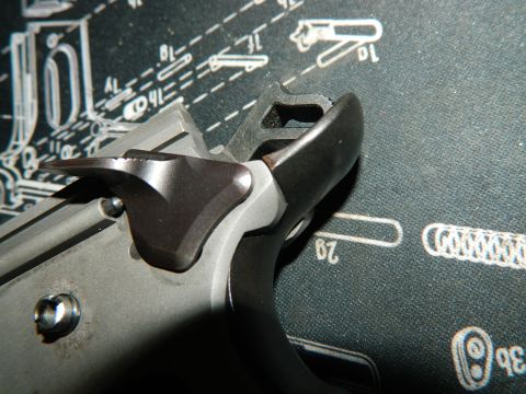 1979 Ford Bronco - Detail of firearm components, including the hammer and trigger assembly, resting on a gunsmithing mat.