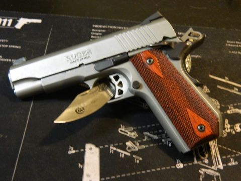 1979 Ford Bronco - A close-up view of a Ruger pistol and a Case knife on a gun mat with diagrams.
