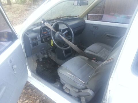 1991 Ford Festiva - The interior of a white car is shown with worn seats and a visible dashboard.