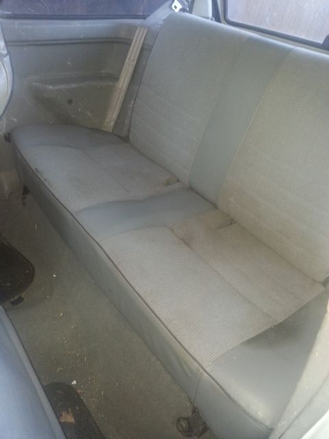 1991 Ford Festiva - Interior view of a gray fabric rear seat, showing a wooden support beam.