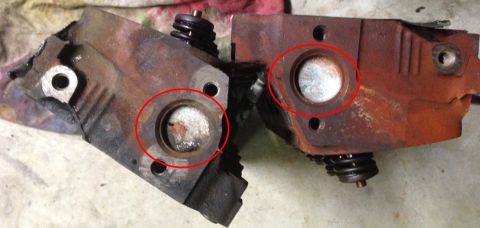 1993 Ford Bronco - Two engine cylinder heads, showing signs of wear and rust, are displayed with key areas circled in red.