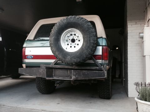1989 Ford Bronco - The rear of a white Ford Bronco is shown, a spare tire mounted on the tailgate.