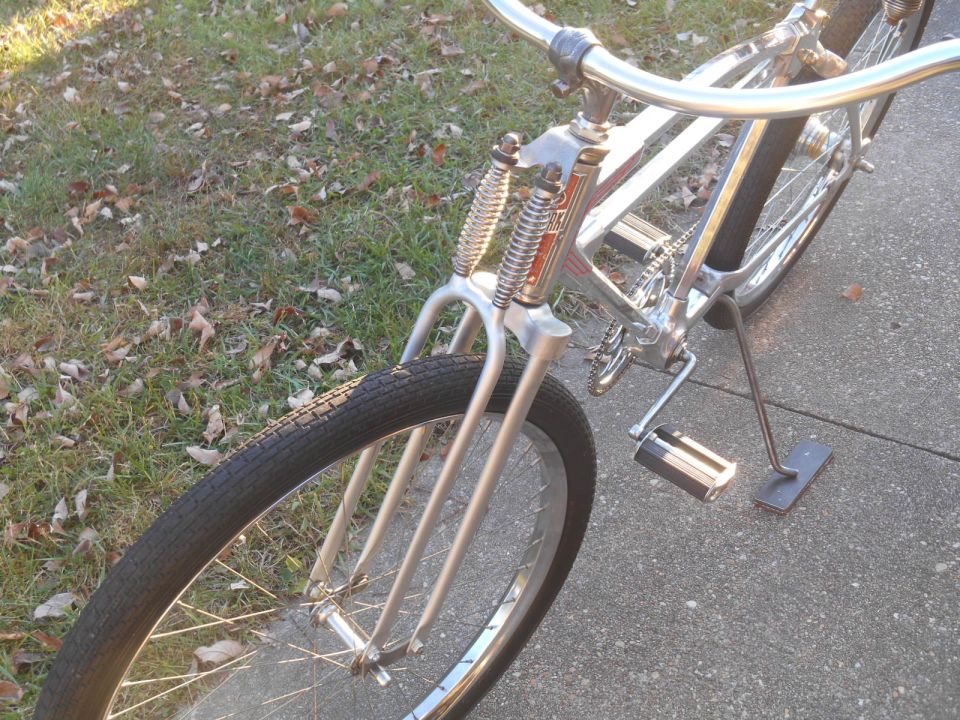 front wheel and handlebars of a chrome bicycle with a kickstand