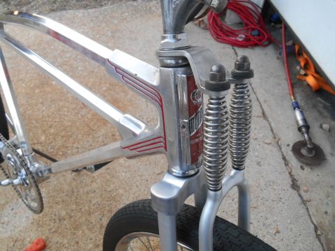 Chrome bicycle frame with red pinstriping and dual front suspension springs
