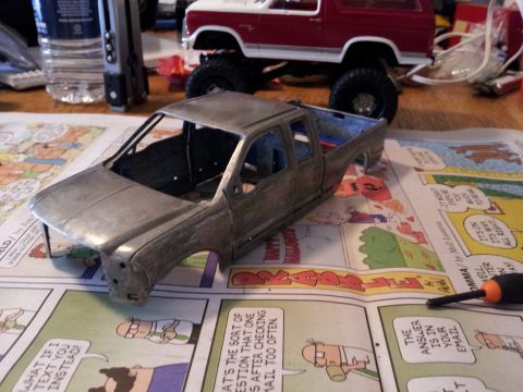 1995 Ford Bronco - Model truck body and model SUV on a table covered with comic pages.