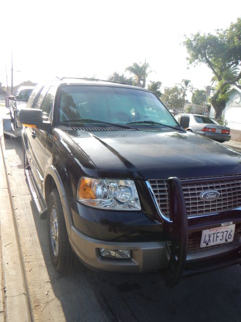 2003 Ford Crown Victoria - Black Ford Expedition with chrome grille and front brush guard, plate 4XTF376, parked on a residential street.
