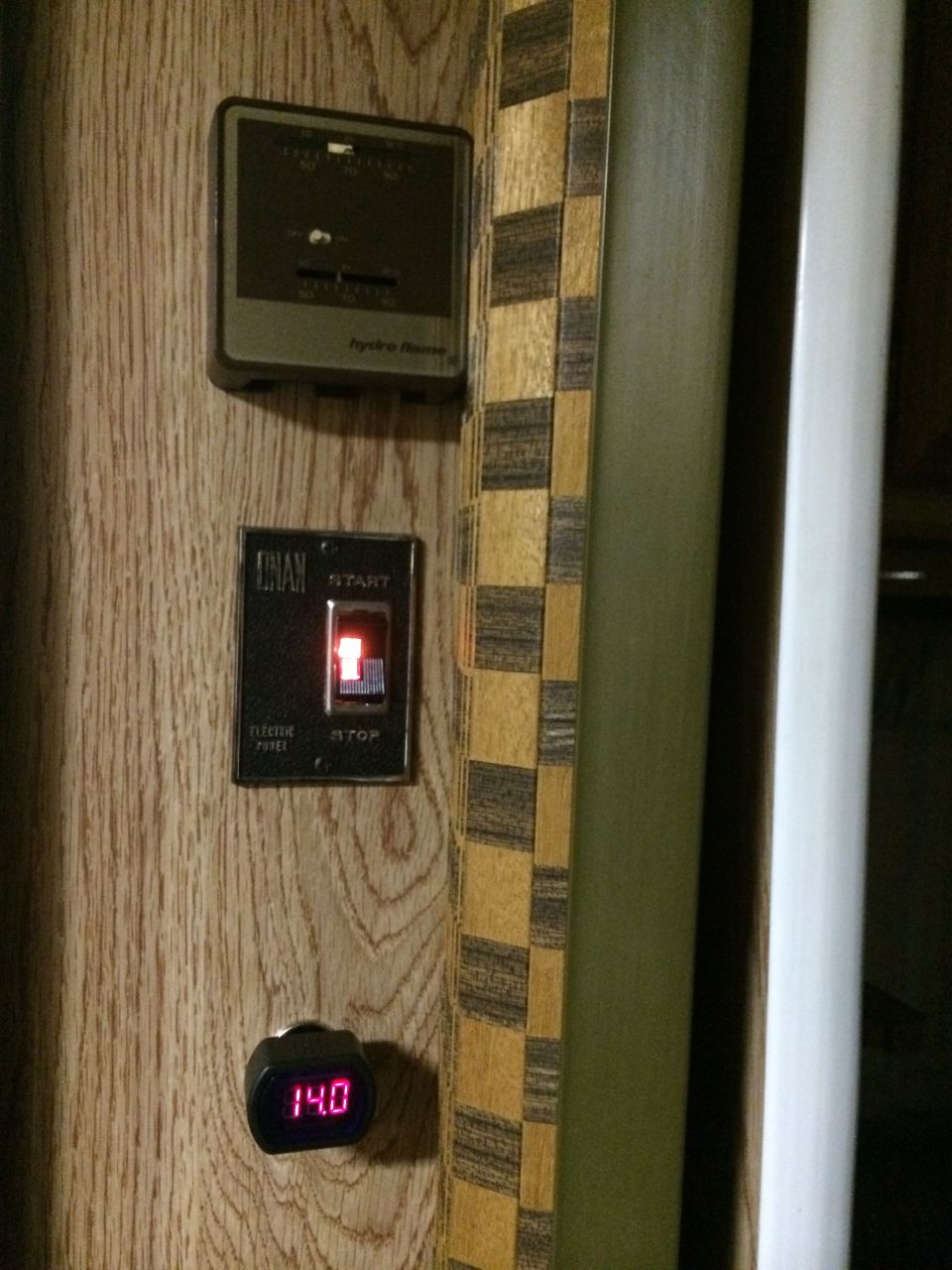 Wood-paneled interior with a digital 14.0 gauge, a start/stop switch, and a climate control unit