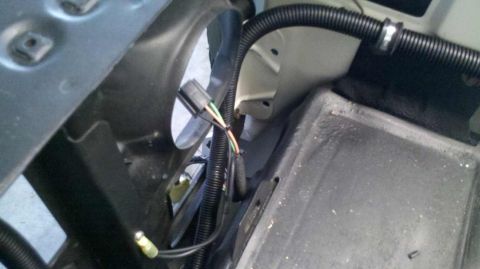 1982 Ford Bronco - A close-up view shows a bundle of wires connected to a black electrical connector. The wires are sheathed in black corrugated tubing and ru…