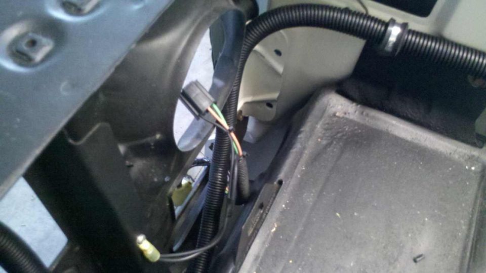 Wires and connector in corrugated tubing next to a metal bracket.