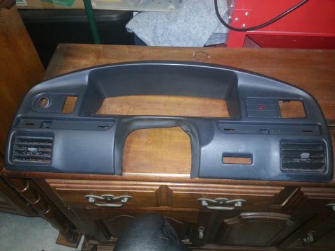 1994 Ford Bronco - Photograph of a removed vehicle dashboard bezel resting on a cabinet, not a technical document.
