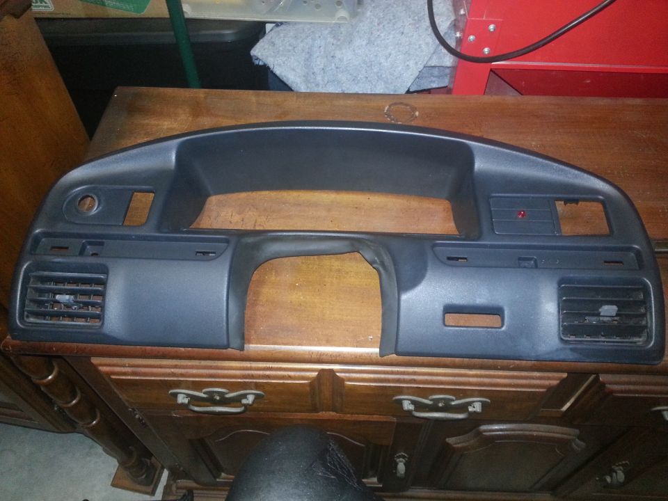 Photo of a removed dash bezel panel on a cabinet