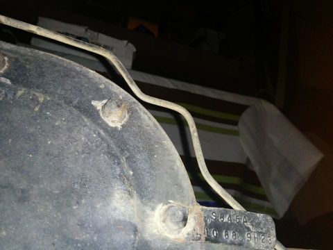 1988 Ford Bronco - A close-up view shows a metal plate with stamped text "S845A 10 08. 9H23" attached to a dark, textured surface, likely a vehicle part. A th…