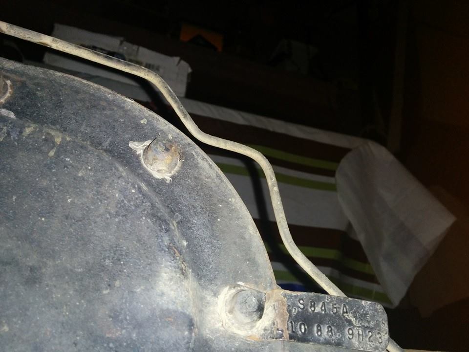 Vehicle part with stamped text S845A 10 08. 9H23 and a metal tube.