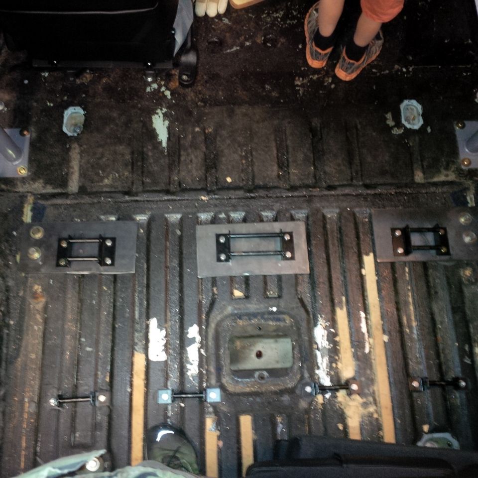 Vehicle floor with metal mounting plates installed.