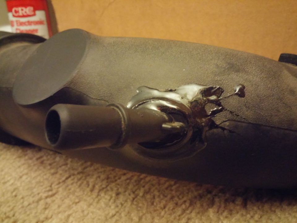 Photo of an air intake duct with applied black sealant or adhesive