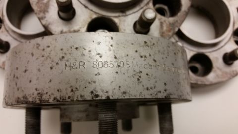2001 Ford Crown Victoria - Close-up photograph of an H&R wheel spacer showing a part number stamped into its edge, not a technical document.