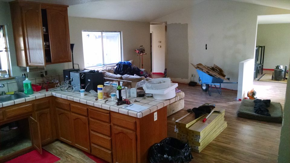 A room undergoing renovation with construction materials and furniture.