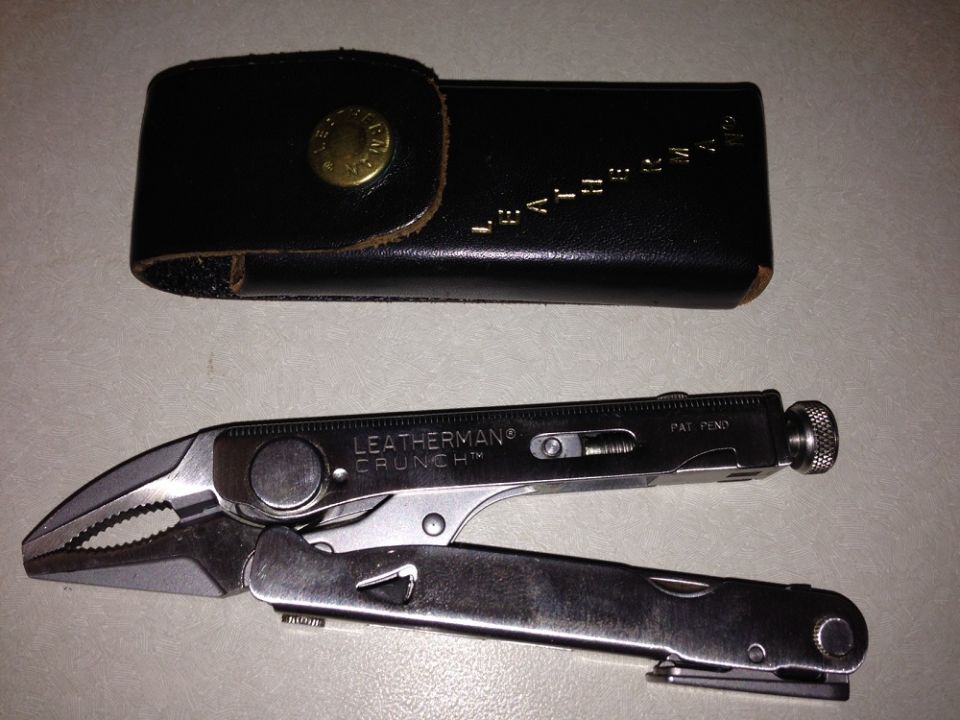 Black car part, possibly a headlight assembly, and a pair of pliers