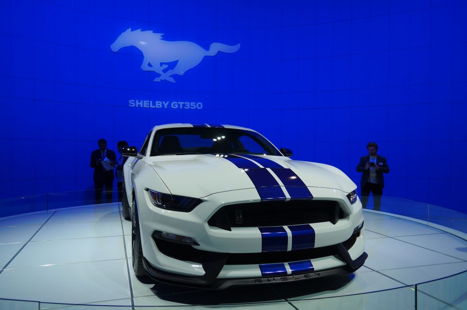 White Ford Shelby GT350 Mustang with blue stripes on display.