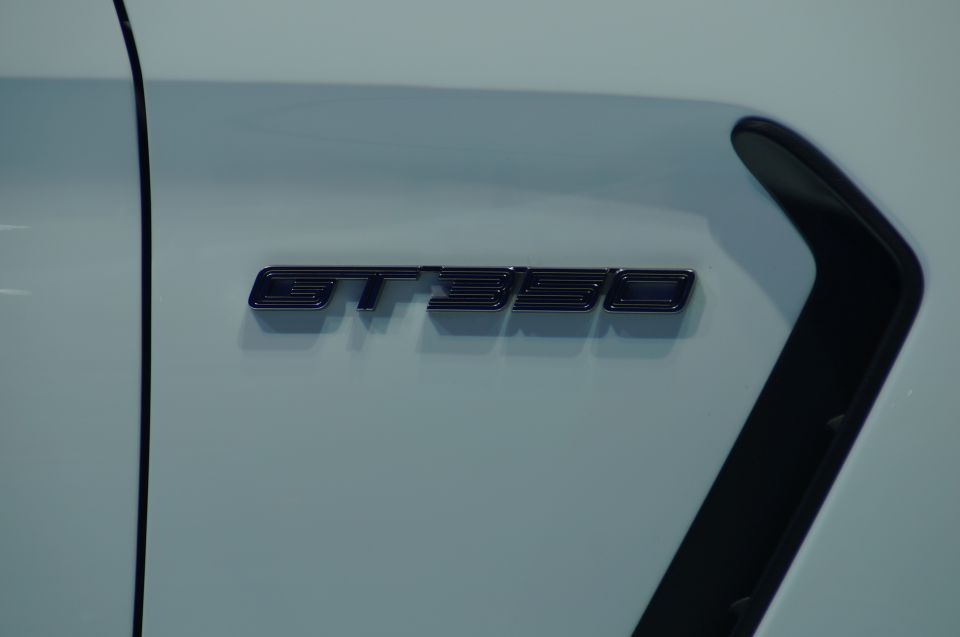 Black GT350 badge on a light blue car with a black vent.