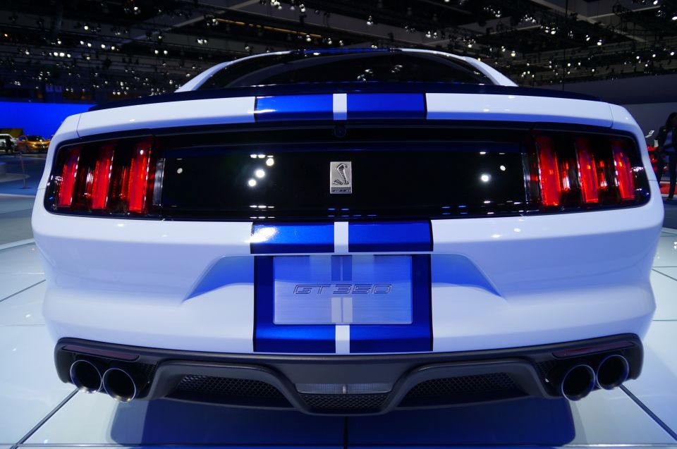 Rear view of a white Ford Mustang GT350 with blue racing stripes