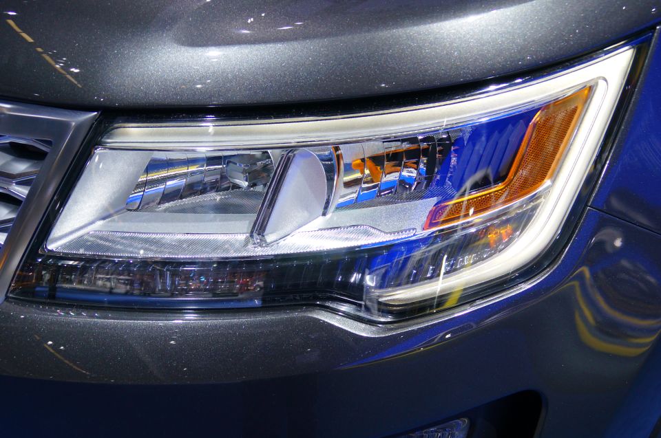 Close-up of a car's driver side headlight assembly, dark gray vehicle.